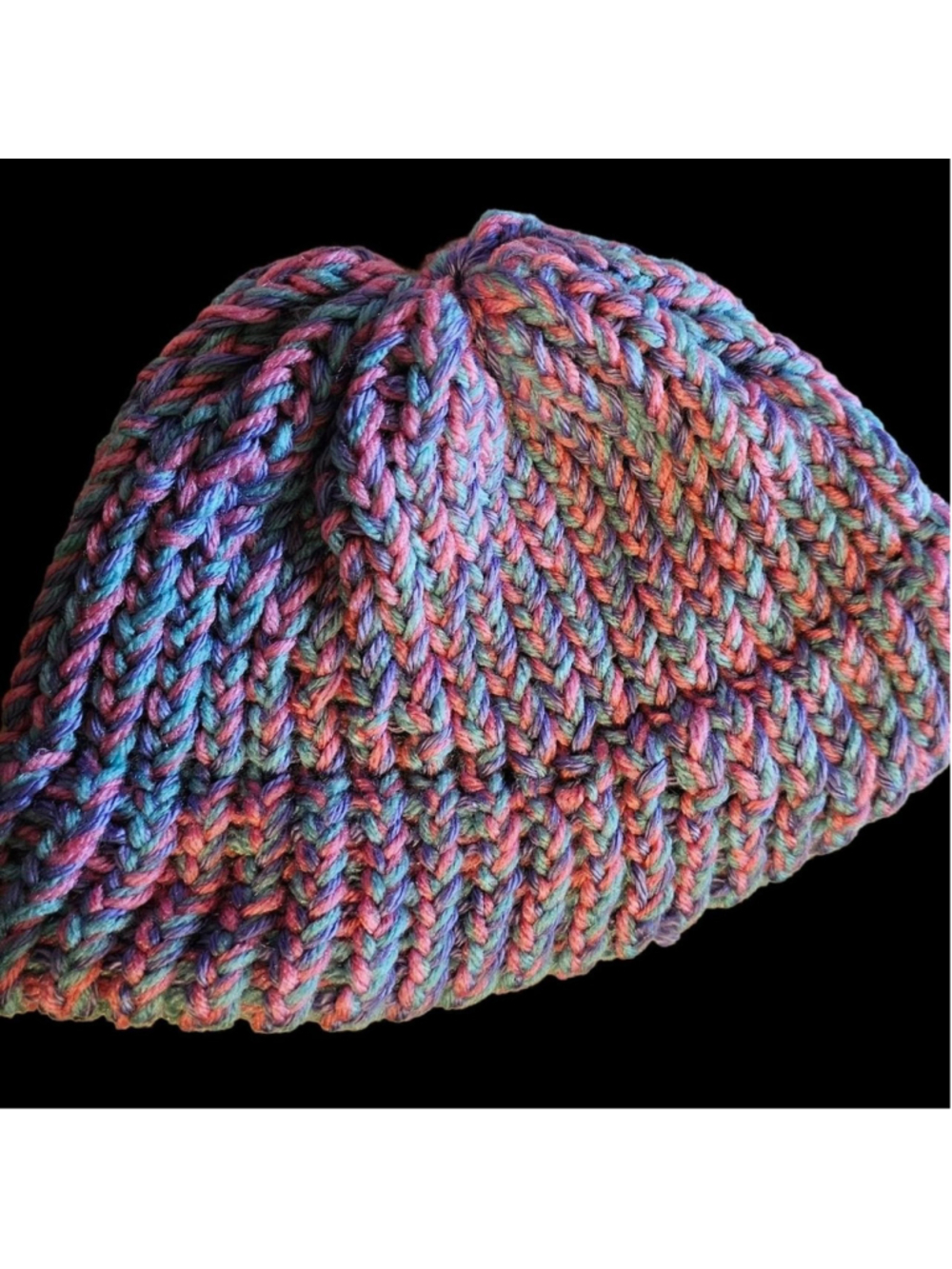 This handcrafted beanie features a vibrant, multi-colored variegated yarn knit i
